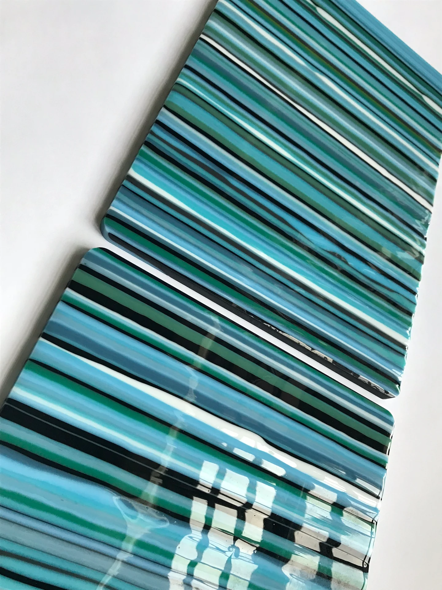 Close view of blue and turquoise stripes on a glass panel