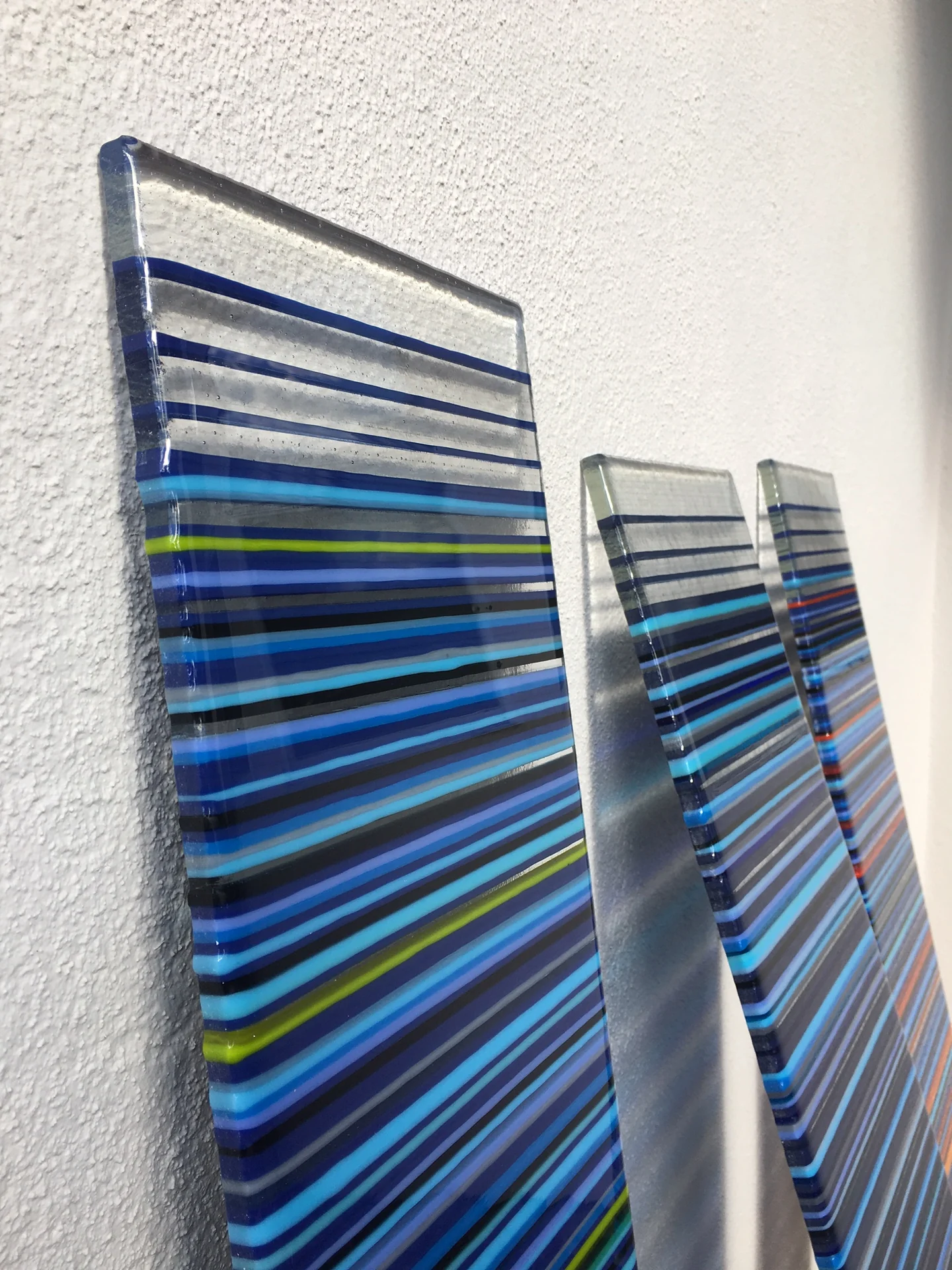 Angled close view of blue-striped panels against a pale wall
