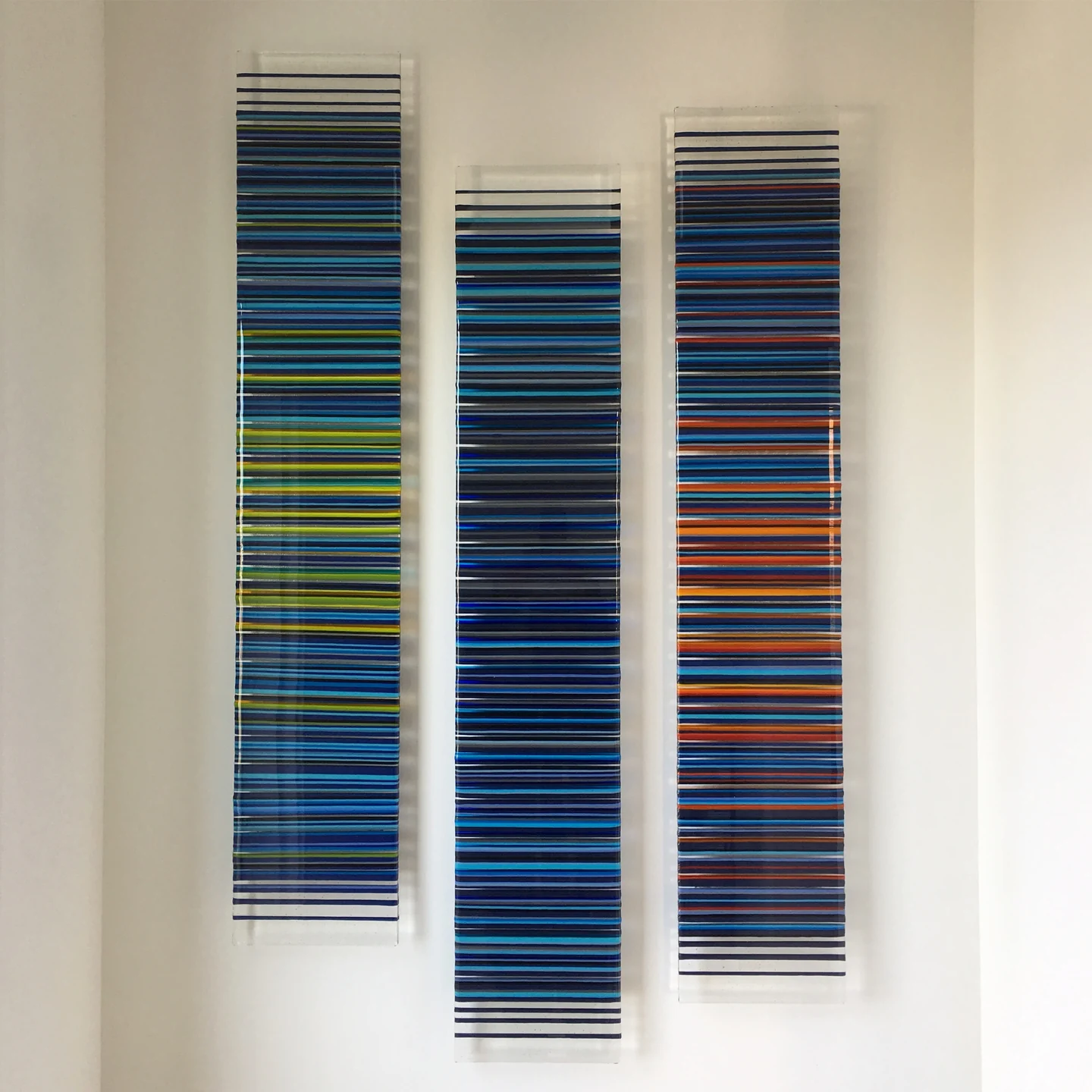 Three tall blue-striped panels hanging side by side on a pale wall