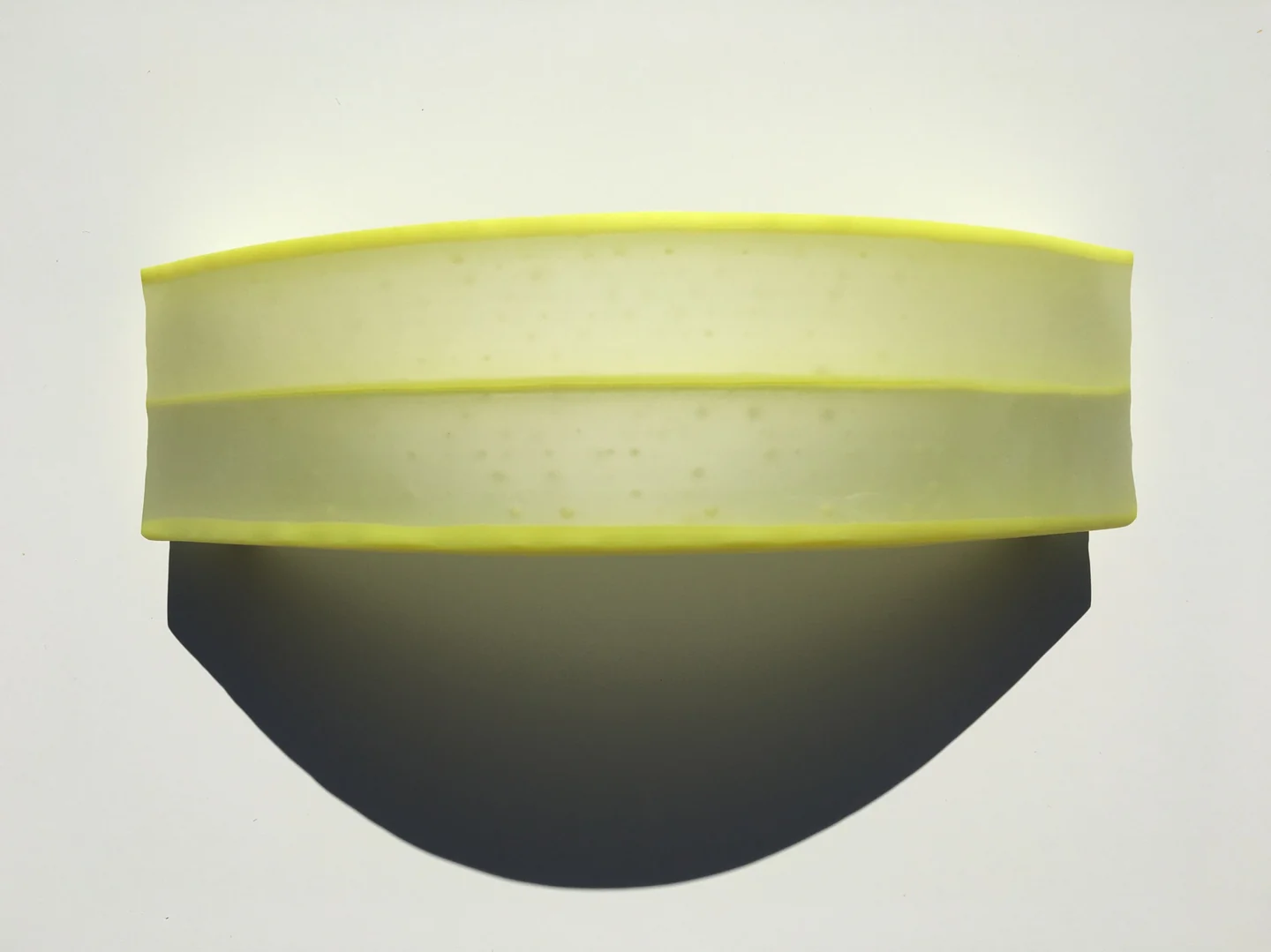 A broad yellow-green banded upper section sits above a dark rounded lower section on a pale background.