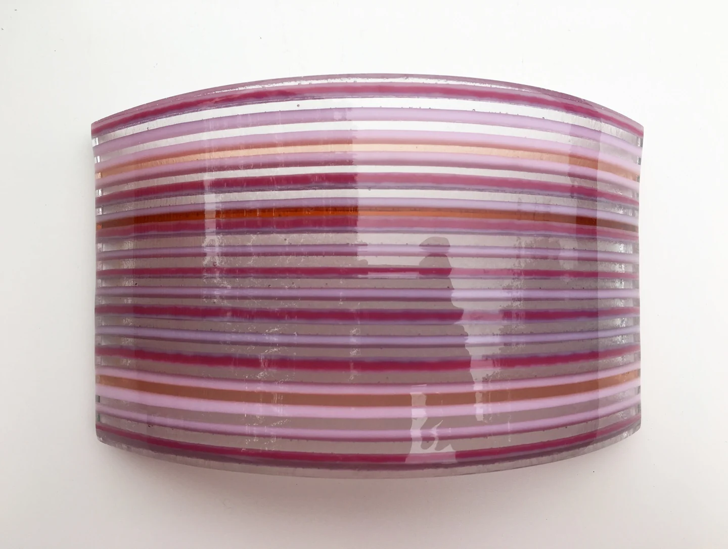 A broad curved form is crossed by closely spaced pink, mauve and pale horizontal stripes on white.