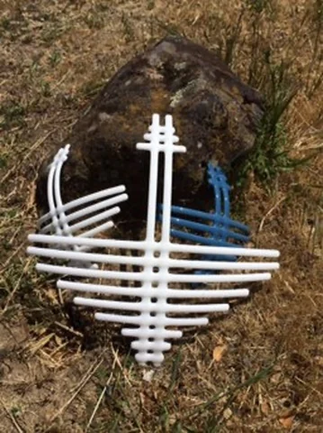 A white open grid of horizontal and vertical lines lies over dark rough ground, with a few blue lines across its middle.