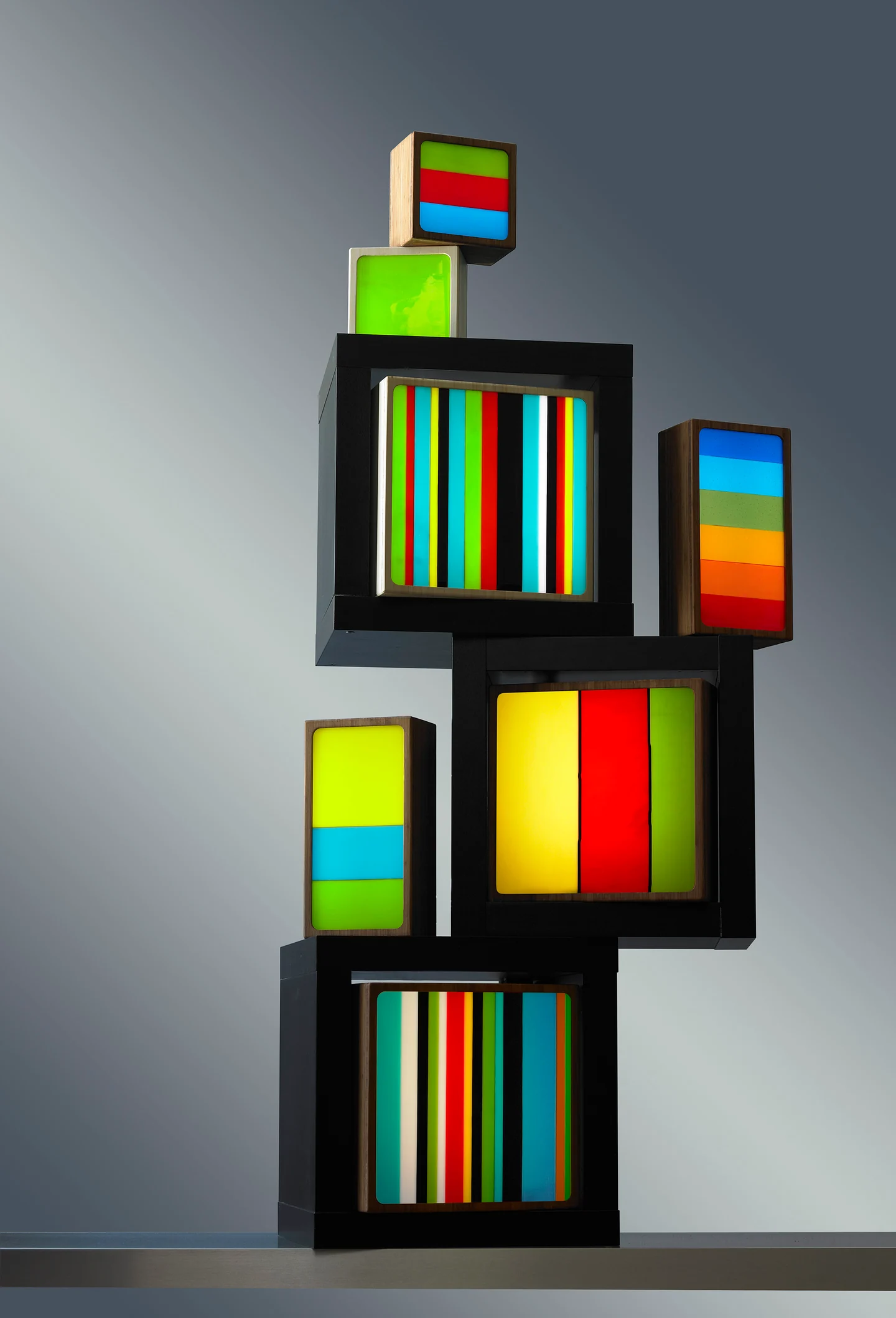 A group of colourful illuminated boxes stacked at different heights against a grey background