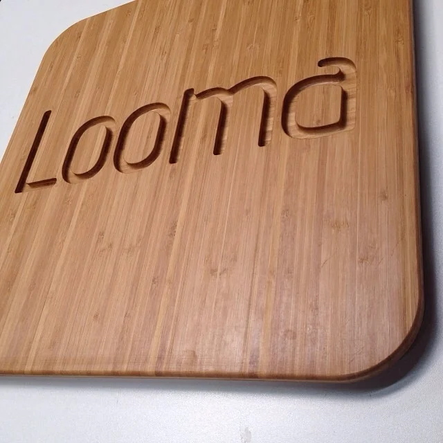 Looma lettering carved into a wooden panel